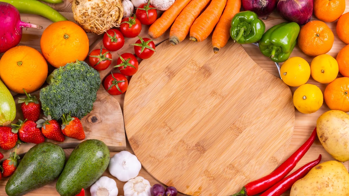 Discover a vibrant assortment of fresh fruits and vegetables arranged on a wooden board. Perfect for healthy eating inspiration.